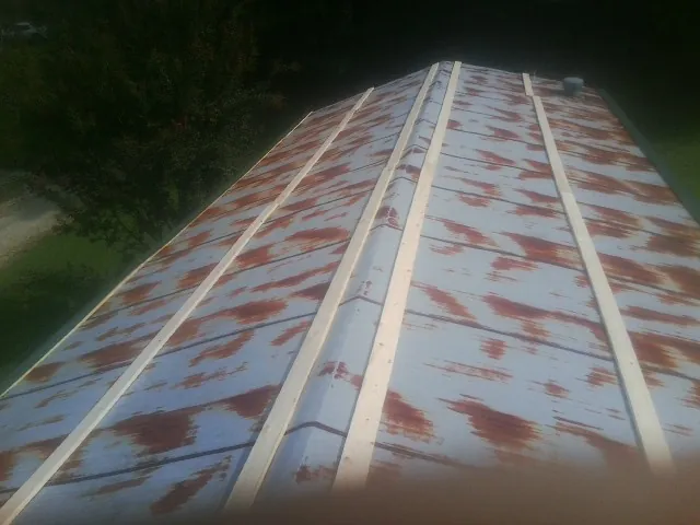 Rusted metal roof panels with new wood purlins before replacement — Storm Damage Roof Repair in Blachly by Roofing Brothers